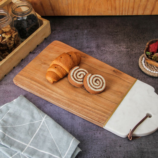 Acacia wood and marble serving board with food displayed.
