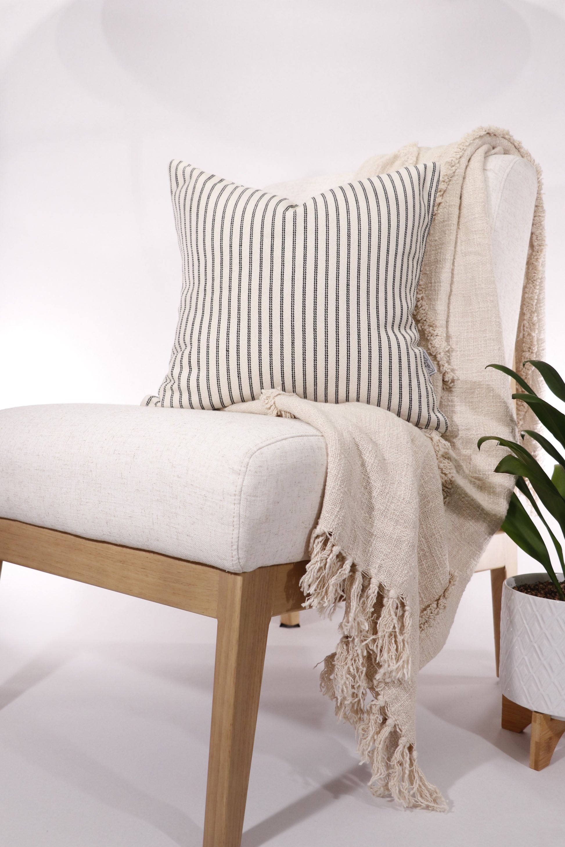 Black and ivory stripe 18x18 pillow cover displayed on a chair.