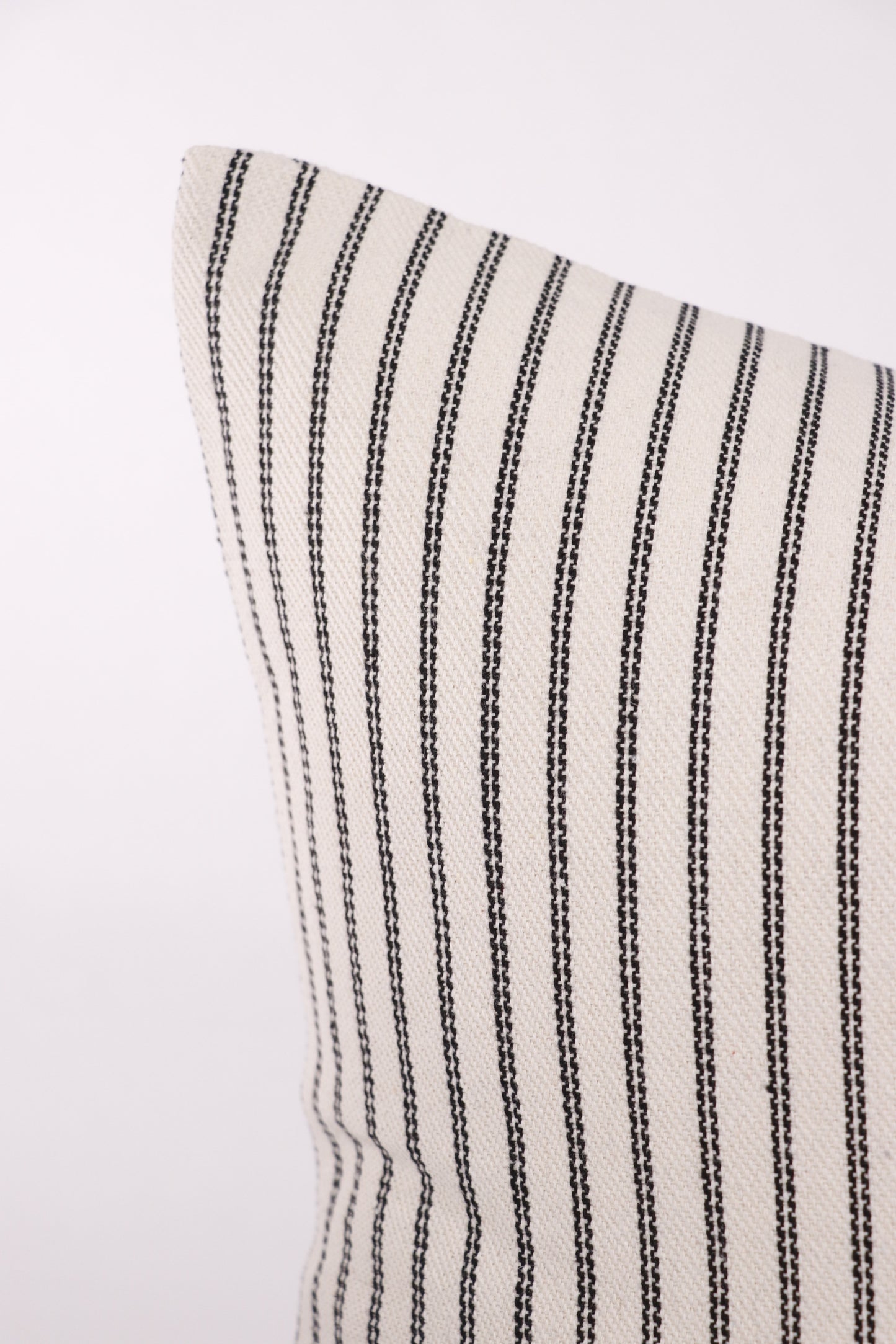Close up of 18x18 black and ivory pillow cover corner.