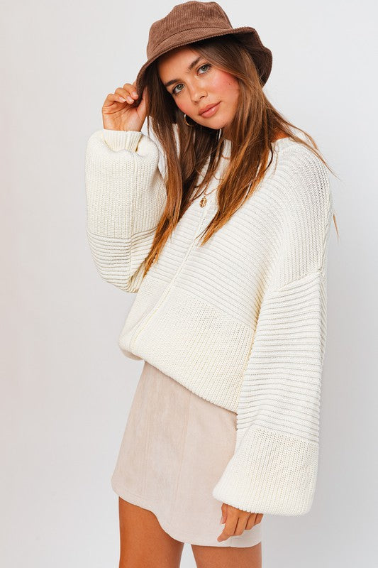 Model wearing white knit sweater.