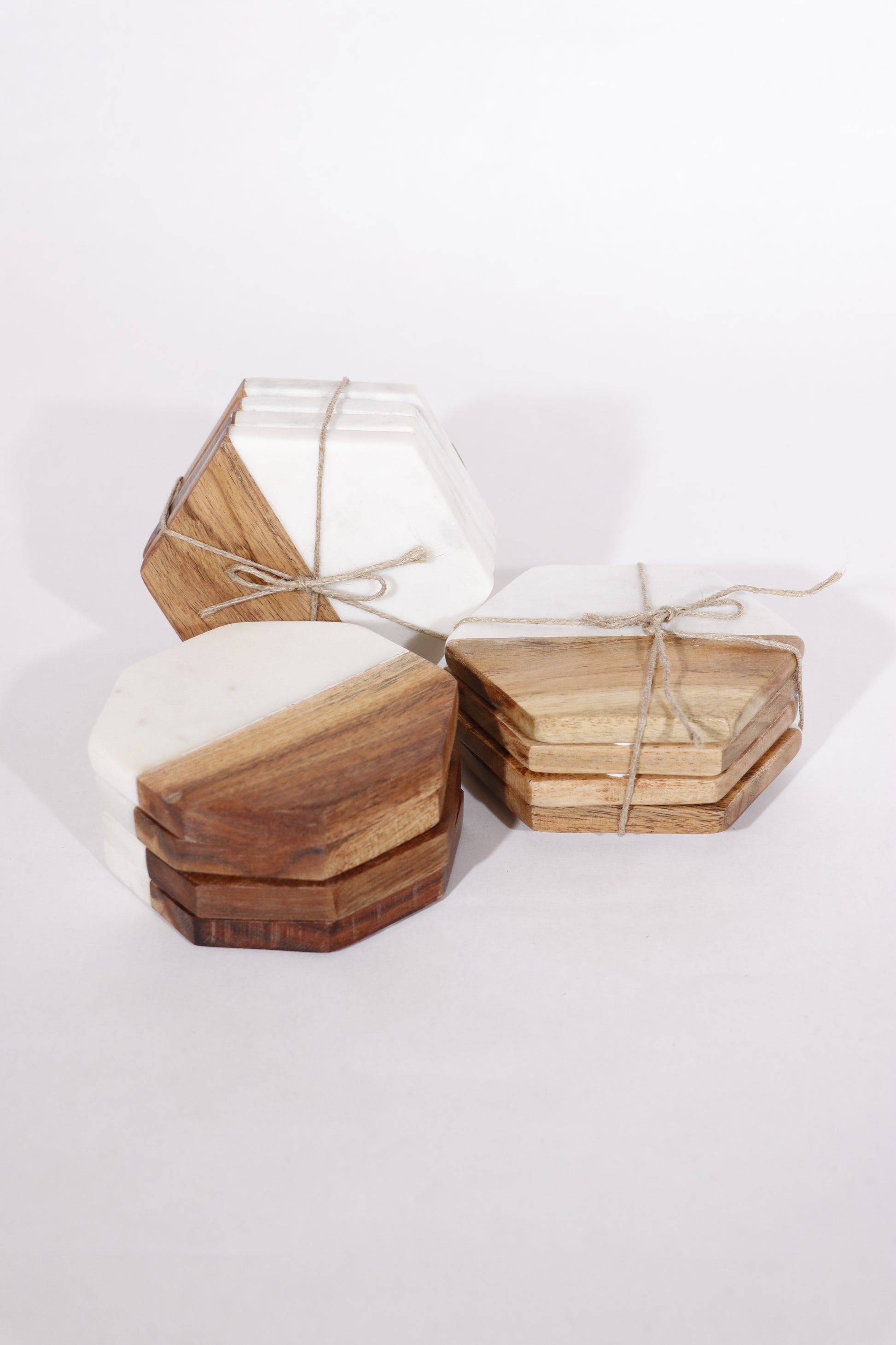 Three sets shown of acacia wood and marble coaster sets.